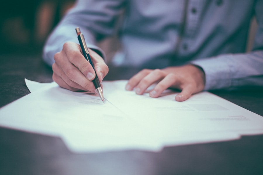 A person writing notes by hand at a desk